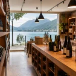 A refined wine shop in Annecy with bottles of Savoie wine, warm wooden shelves, and a soft view of Lake Annecy and the Alps.