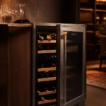 Elegant modern 18-bottle wine cooler with glass door in a sophisticated contemporary kitchen setting with warm ambient lighti